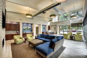 a large living room with a blue couch and chairs
